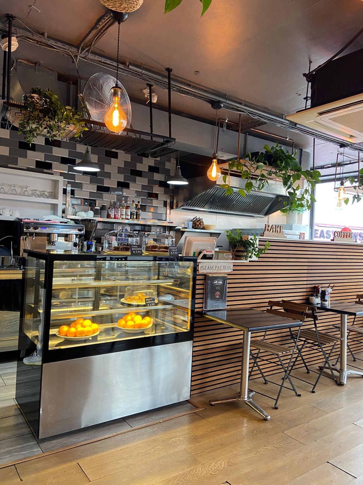 Wide view of the counter, wood-slat wall and bistro seating